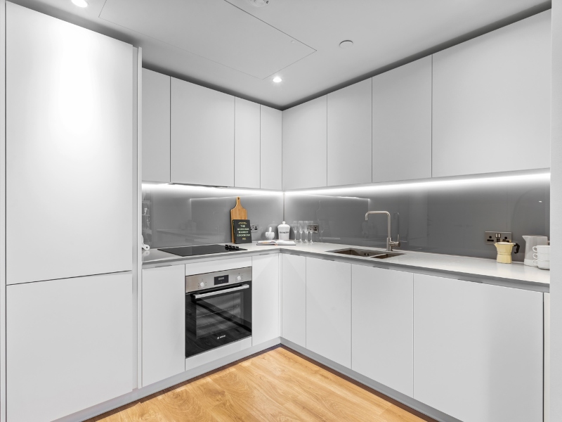 Interior photo of the Kitchen area, white cabinets, oven and sink in a One Bed Apartment Showhome