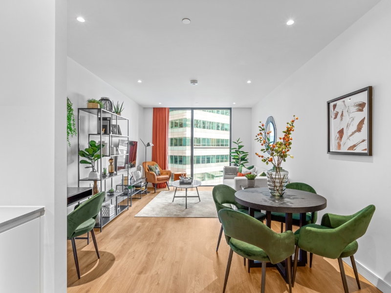 Interior photo of a lounge with sofa and table and window view across Canary Wharf from a One Bed Apartment at Hampton Tower, SQP