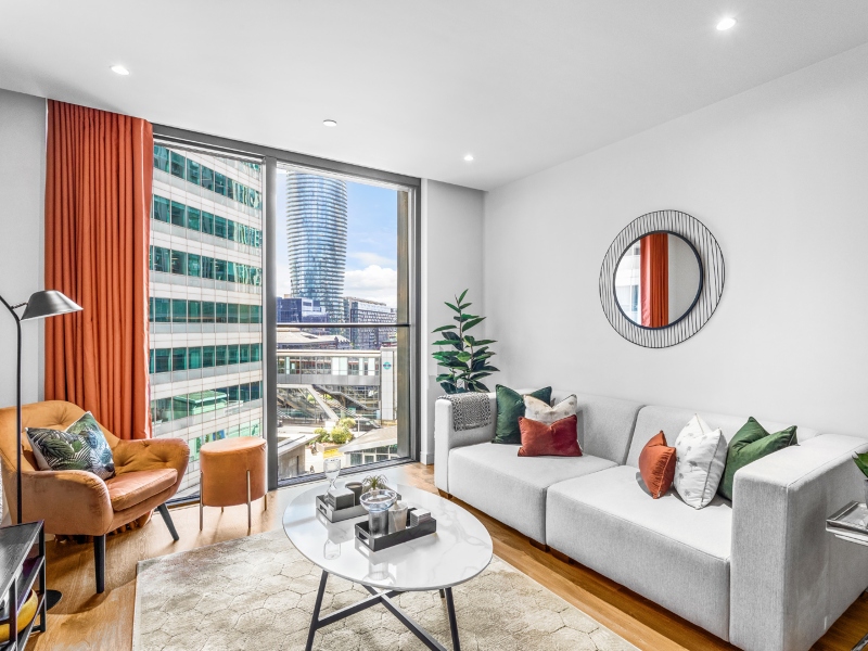 Interior photo of a lounge with sofa and table and window view across Canary Wharf from a One Bed Apartment at Hampton Tower, SQP