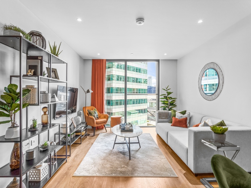 Interior photo of a lounge with sofa and table and window view across Canary Wharf from a One Bed Apartment at Hampton Tower, SQP