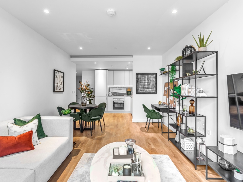 Interior photo of a furnished lounge with sofa, table and shelves towards the kitchen, one bedroom apartment at Hampton Tower, SQP