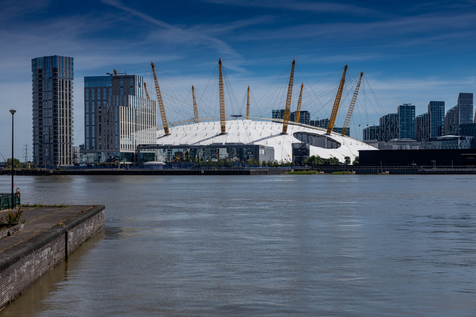 Exterior daytime photo across the River Thames towards theO2 arena and shopping outlet near Hampton Tower, South Quay Plaza