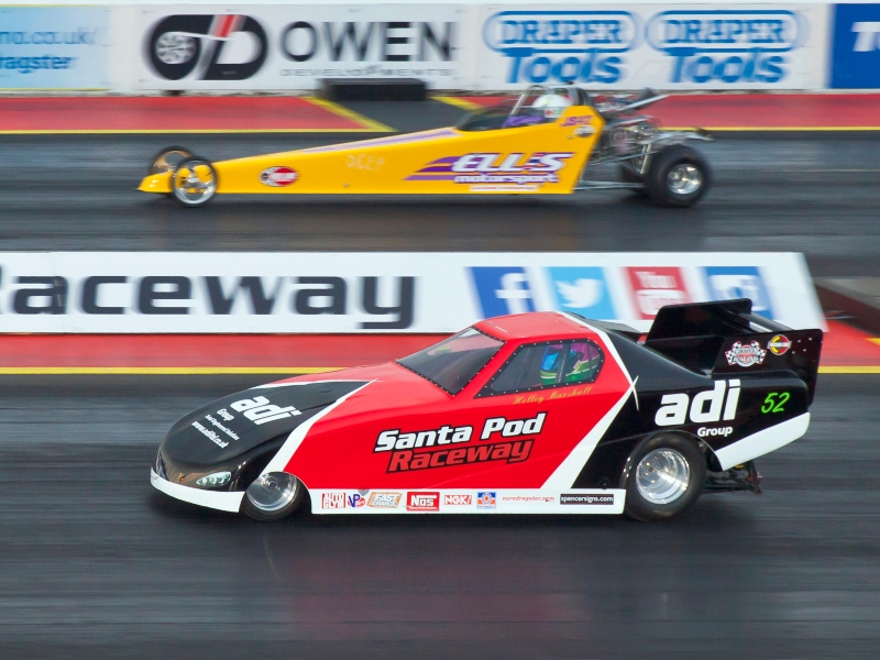 Two dragster cars in action on the Santa Pod raceway track