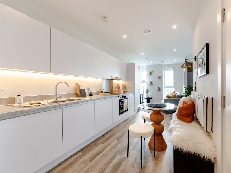 Photograph of plot 1502's kitchen-diner space with a view of the lounge, which is a studio apartment at The Acer Apartments in White City, London.