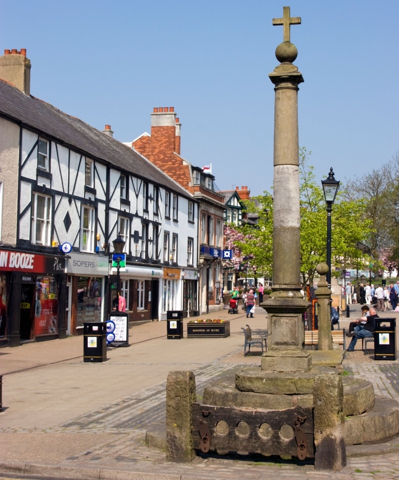 Outdoor summer scene in the town of Poulton-le-Fylde, Lancashire, with its Market Cross and medieval stocks