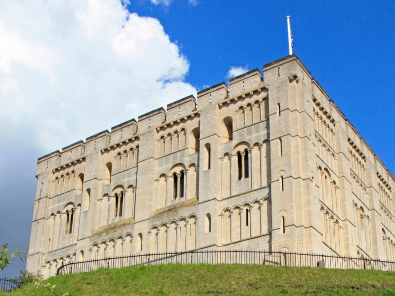 View of the walls and corner of Norwich Castle atop a grassy hill
