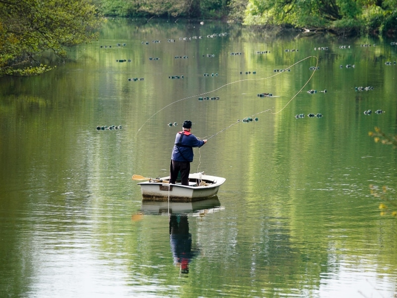 Photo of a fisherman, fishing from a boat on Broadwater Lake