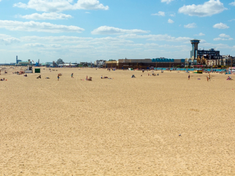 Great Yarmouth sandy beach with a cloudy blue sky.