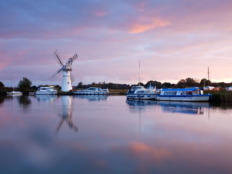 Sunset reflecting on the lake with a white windmill, Thurne Mill