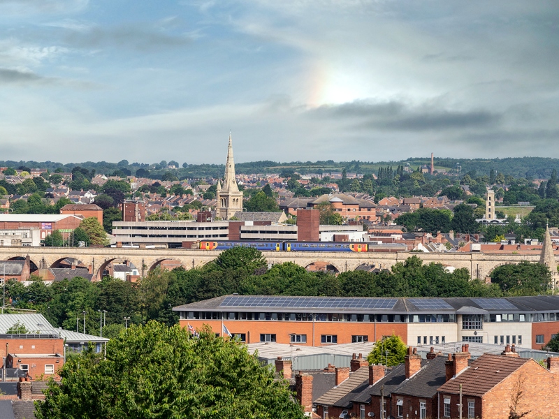 Town of Mansfield UK with St Marys John Church Pleasely Pit and Fire Station in view train crossing viaducts to centre aerial view landscape sky wide angle looking over market .