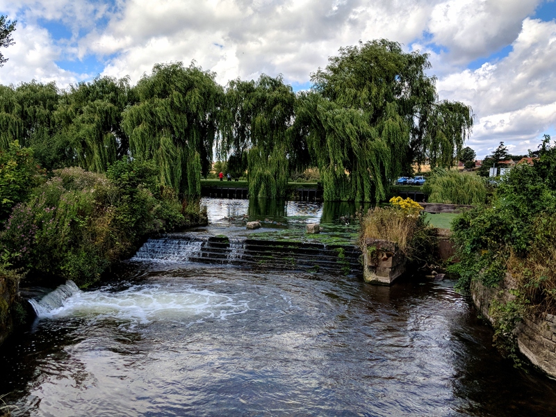 Weir and mill race at Carr Park Lake in the midday summer sun, Warsop, Nottinghamshire, UK