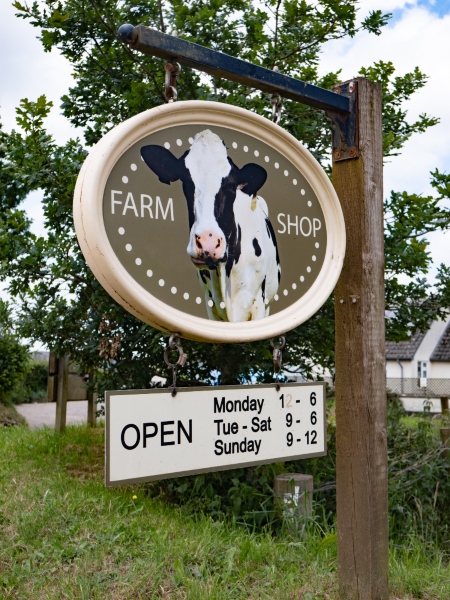 Farm shop sign outside with oval sign with a cow