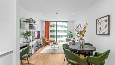 Interior photo of a lounge with sofa and table and window view across Canary Wharf from a One Bed Apartment at Hampton Tower, SQP