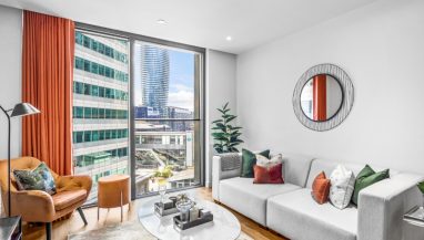 Interior photo of a lounge with sofa and table and window view across Canary Wharf from a One Bed Apartment at Hampton Tower, SQP