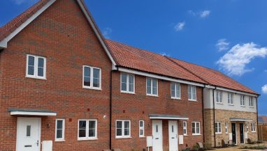 Exterior view of a terrace of homes at Sorrel Grove, Norfolk, with parking spaces