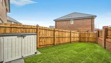 Photo of the garden exterior of a three bedroom house at Meden Meadow, showing the garden storage, lawn and fencing