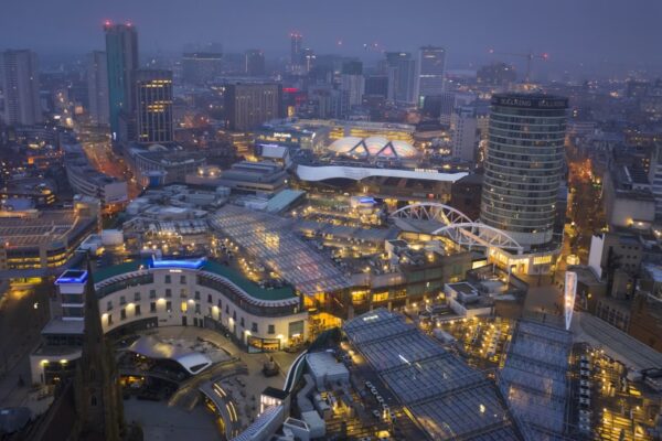 Birmingham UK city centre at dawn as mist starts to fade and lights emerge.
