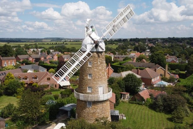 Brown and white wind mill surrounded by greenery and houses, Melton Mowbray